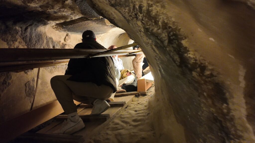 Crouching through a narrow passage inside the Great Pyramid of Giza