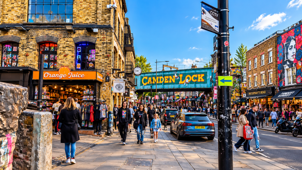 Camden Lock railway bridge in Camden Town, London, with colourful street art, independent shops and people exploring the lively streets.