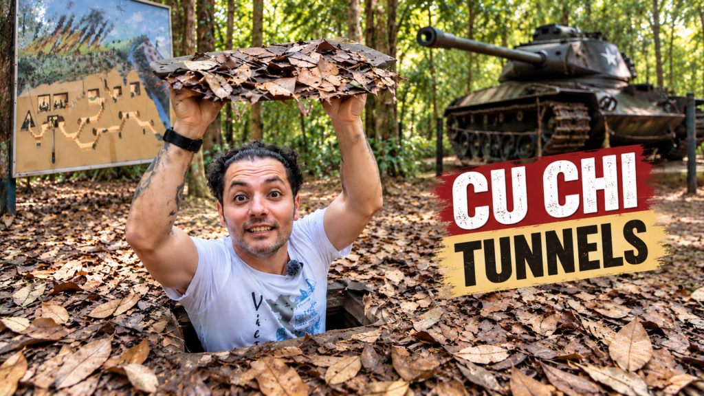 Traveller emerging from a hidden entrance at the Cu Chi Tunnels near Ho Chi Minh City, Vietnam