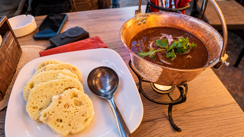 Traditional Czech beef goulash served in a copper pot with bread dumplings at a restaurant in Prague.