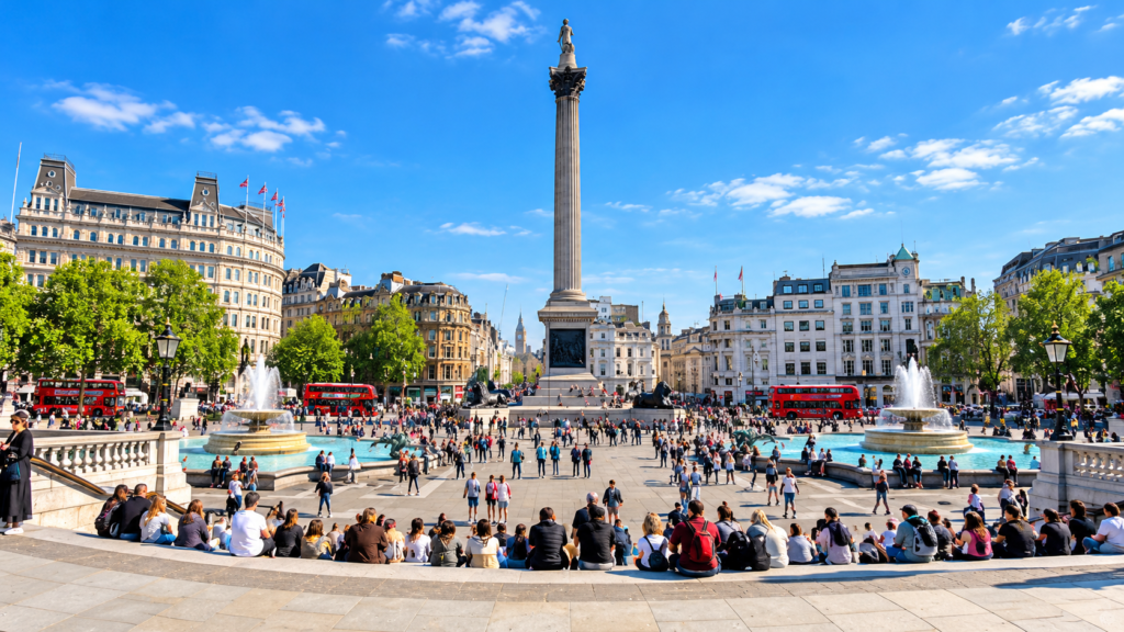 Trafalgar Square in central London, featuring Nelson’s Column, famous fountains, historic buildings and visitors enjoying a sunny day.